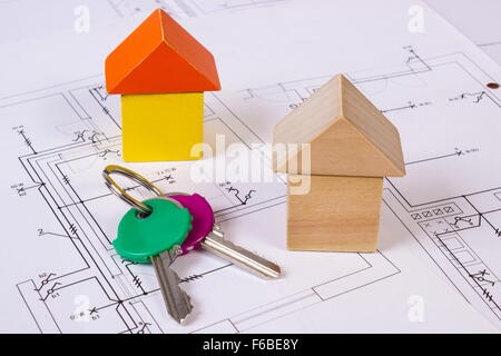 Case fatte di forma di blocchi di legno e le chiavi di casa giacente su apparecchiature elettriche i disegni di costruzione della casa, concetto di costruzione di casa, Foto Stock