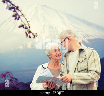 Felice coppia senior con mappa di viaggio sulle montagne Foto Stock