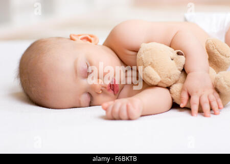 Spensierato dormire bambino con il giocattolo morbido Foto Stock