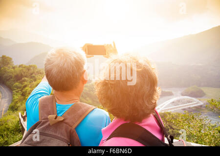 Felice coppia Senior escursioni sulle montagne e tenendo selfies Foto Stock