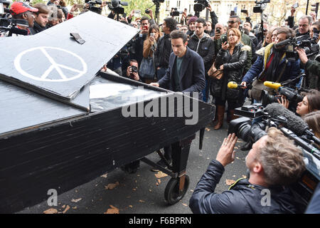 Il pianista Davide Martello riproduce la canzone 'Imagine' davanti al luogo in cui ascoltare musica 'Bataclan' di Parigi, Francia, 14 novembre 2015. Almeno 129 persone sono state uccise nel corso di una serie di notte gli attentati a Parigi dal 13 al 14 novembre 2015. Foto: UWE ANSPACH/dpa Foto Stock