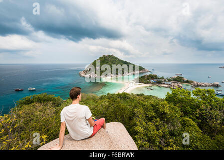 Giovane uomo che guarda verso Koh Nang Yuan, anche Nangyuan, Koh Tao, Golfo di Thailandia, Tailandia Foto Stock