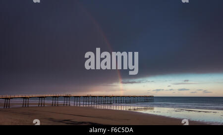 Bellissimo arcobaleno rosso incandescente all'alba su Saltburn Pier. A Cambs, Cleveland, North Yorkshire Foto Stock