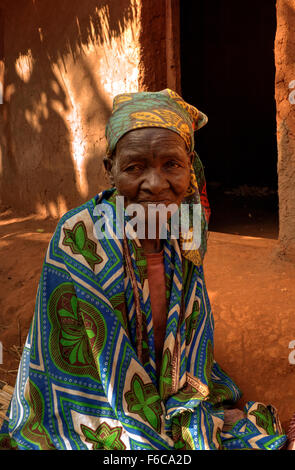 Un ritratto di un vecchio nero donna che indossa un chitenje sulle spalle per mantenere caldo in inverno in Dedza, Malawi, Africa Foto Stock