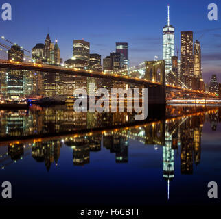 Manhattan waterfront riflessa nell'acqua di notte, la città di New York, Stati Uniti d'America. Foto Stock