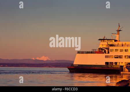 WASHINGTON - Il traghetto Mukilteo-Clinton e Mount Baker immerso nei colori del tramonto dal Mukilteo waterfront sul possesso Sound Foto Stock