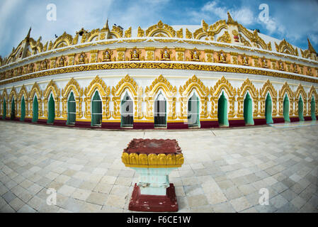 U min Thonze Pagoda Entrance Arches Sagaing Myanmar // SAGAING, Myanmar - gli archi d'ingresso decorati della Pagoda di U min Thonze (conosciuta anche come OoHminThoneSel Pagoda) conducono al colonnato principale curvo che ospita 45 statue uniche di Buddha. La pagoda, originariamente fondata dal re Tarabya i tra il 1327-1335 e ricostruita nel 1847 in seguito ai danni del terremoto, presenta un caratteristico design a forma di mezzaluna costruito nella collina di Sagaing. Il nome della struttura si traduce in "Thirty Caves Pagoda", riferendosi ai suoi 30 cancelli d'ingresso ornati, sebbene in realtà contenga 45 immagini di Buddha che rappresentano i 45 anni fa Foto Stock