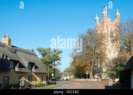 Un villaggio street, cottage con il tetto di paglia e Chiesa di Tutti i Santi Cottenham Cambridgeshire Regno Unito Foto Stock