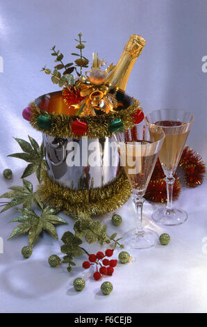 Festive Capodanno Natale ancora in vita con una bottiglia di vino in ghiaccio, due bicchieri e verde palle di Natale su uno sfondo luminoso. Foto Stock