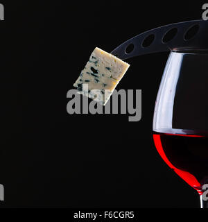 Il Gorgonzola e vino rosso su sfondo nero Foto Stock