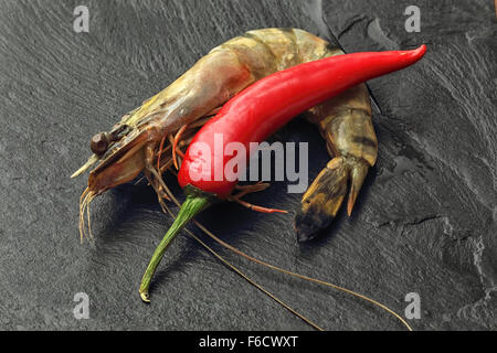 Materie non pelati gigante con Gamberi Peperoncino rosso su nero ardesia sfondo. Foto Stock