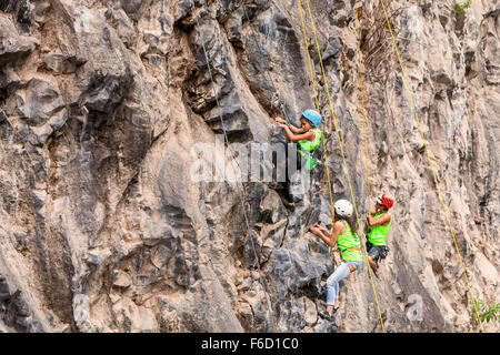 Banos, Ecuador - 30 Novembre 2014: la sfida di basalto del Tungurahua, giovane gruppo di Alpinisti scalare una parete di roccia in Banos Foto Stock