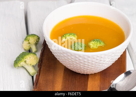 Vegetali minestra di crema decorate con pezzi di cavolfiore, nella ciotola bianco su servita in eco ristorante in stile tabella. Foto Stock