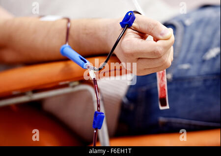 Dettaglio con la mano di un donatore di sangue e una plastica sacca di sangue in un ospedale Foto Stock