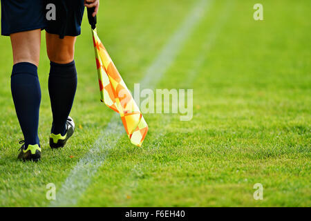 Arbitro assistente in movimento lungo il diversivo durante una partita di calcio Foto Stock