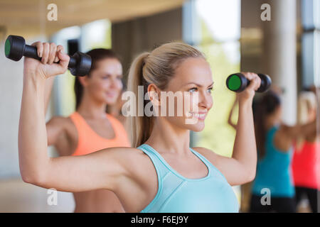 Un gruppo di donne che esercitano con manubri in palestra Foto Stock