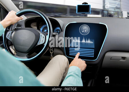 Ravvicinata di un uomo alla guida di auto con sistema audio Foto Stock
