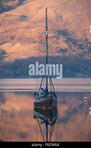 Area di Glen Coe, Scozia. Pittoresca vista del tramonto di una imbarcazione a vela ancorata in Loch Leven vicino a Glencoe Boat Club. Foto Stock