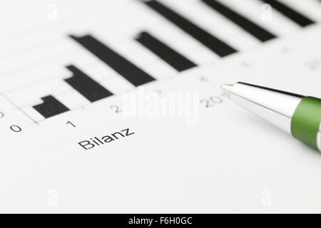 Primo piano della giacente su un diagramma di equilibrio di penna verde a breve la messa a fuoco Foto Stock