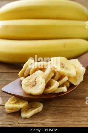 Banana chips, frutta secca su di un tavolo di legno Foto Stock