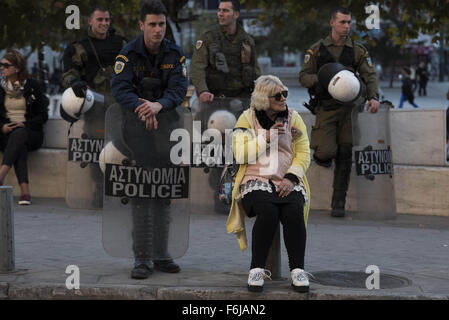 Atene, Grecia. 17 Nov, 2015. Una signora riposa accanto ai poliziotti antisommossa. Circa 20.000 persone sono scese nelle strade segnando il XLII anniversario del Politecnico di Atene sollevazione contro i colonnelli" junta che durò dal 1967 al 1974. Credito: Nikolas Georgiou/ZUMA filo/Alamy Live News Foto Stock