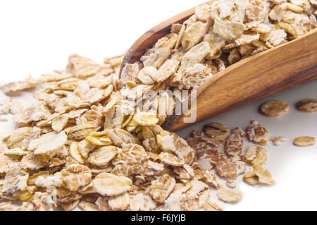 Fiocchi di avena nel convogliatore di legno isolato su bianco Foto Stock