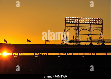 Il sole tramonta dietro il ponte superiore posti a sedere e torre faro montato sul tetto del Wrigley Field, casa dei Chicago Cubs. Chicago, Illinois, Stati Uniti d'America. Foto Stock