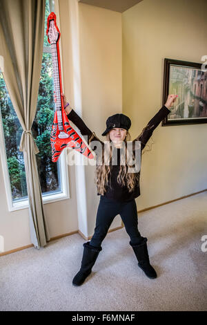 Dieci anni di ragazza che gioca con una finta chitarra in Issaquah, Washington, Stati Uniti d'America Foto Stock