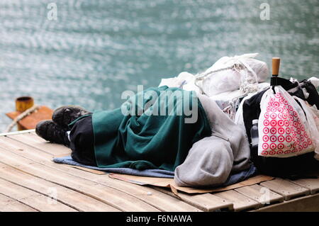 Un senzatetto uomo dorme su un materasso di cartone lungo il fiume Chicago al Lake Shore Drive cavalcavia. Chicago, Illinois, Stati Uniti d'America. Foto Stock