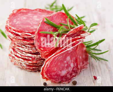 Fette di salame, su un tavolo di legno. Messa a fuoco selettiva Foto Stock