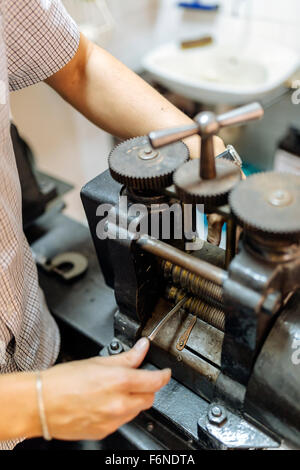 Goldsmith creazione di metallo con l'aiuto di una pressa Foto Stock