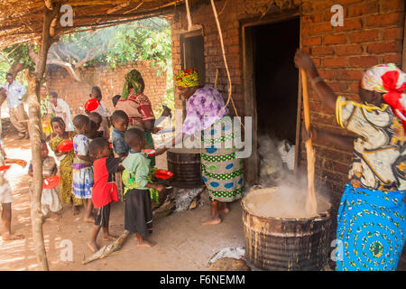 Le donne dalla Chiesa locale di cottura degli alimenti per i bambini delle scuole in tempo di fame nel villaggio di Nyombe, Dedza, Malawi, Africa Foto Stock