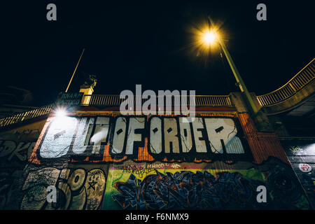 Graffiti su un muro lungo il canale del Danubio di notte, a Vienna, Austria. Foto Stock