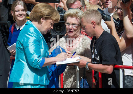 FILE - Un archivio foto datata 25 luglio 2015 mostra il Cancelliere tedesco Angela Merkel (CDU, L) firma il suo autografo durante la fase di apertura della Bayreuth Festival di Bayreuth, Germania. Foto: Tobias Hase/dpa Foto Stock