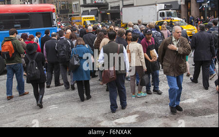 Mattina Rush Hour folle di edificio per uffici lavoratori cross 34th Street e la 7th Avenue in Manhattan. Foto Stock
