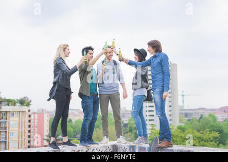 Un gruppo di giovani amici multietnica di fare un brindisi con birre, avendo divertimento - Relax, happy hour, concetto di amicizia Foto Stock