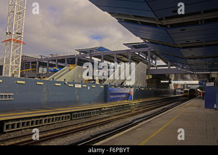 Una vista guardando oltre al nuovo edificio del passeggero scale mobili per accesso alla piattaforma con oltre il ponte ancora coperto. Foto Stock