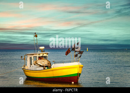 Il pittoresco paesaggio di un tramonto con una barca sulla spiaggia di Sopot, Polonia. Foto Stock