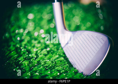 Golf club testa faccia aperta dettaglio di ferro contro il fondo erboso Foto Stock