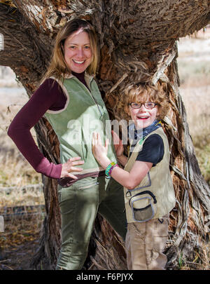 Attraente madre e figlio giovane posano con cani per le fotografie di tree sul ranch Foto Stock