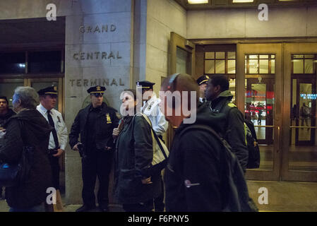 New York, Stati Uniti. Xviii Nov, 2015. Un trio di NYPD ufficiali stand vicino all'ingresso al Grand Central Terminal, sorvegliare ispezioni di traffico come un curioso pedoni guarda. A seguito del rilascio di un nuovo video di Stato islamico fonti suggerendo un imminente attacco terroristico a New York City, maggiori misure di sicurezza sono state messe in atto presso le principali della città i mozzi dei " commuters " incluso Grand Central Terminal, dove il traffico casuale si arresta e pesantemente pattuglie armate sono state attuate. Credito: Albin Lohr-Jones/Pacific Press/Alamy Live News Foto Stock