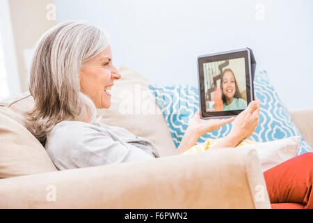 Nonna caucasica videochatting con il nipote sulla tavoletta digitale Foto Stock