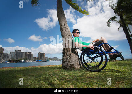 Disabilitato l'uomo giocando in sedia a rotelle sulla spiaggia Foto Stock