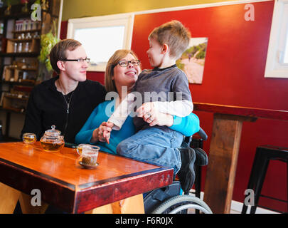 Per paraplegici azienda madre figlio nel negozio di tè Foto Stock