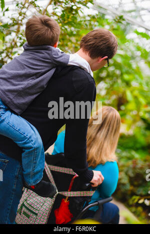 Uomo paraplegico di spinta moglie e figlio di trasporto strada-ferrovia Foto Stock