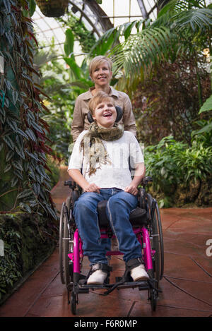 Madre spingendo figlia paraplegico in sedia a rotelle Foto Stock