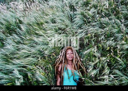 Nero donna posa in erba Foto Stock