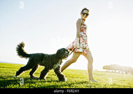 La donna caucasica cane a camminare nel campo Foto Stock