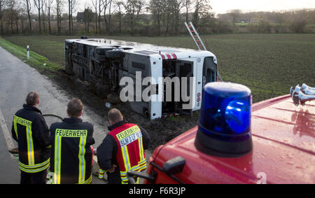 Selm, Germania. Xix Nov, 2015. Un bus giace in una fossa su un campo in Selm, Germania, 19 novembre 2015. Giovedì mattina un autobus che trasportava 80 rifugiati skidded in un fosso sul ciglio della strada, causando la punta su un suo lato. Iniziale di rapporti di polizia di stato più persone sono state ferite. Il bus è stato proveniente dalla sistemazione dei rifugiati alloggiati presso la scuola di polizia in Selm. Come una vettura si avvicinava, il bus trasformato in la spalla non fortificata e scivolato nel fosso. I rifugiati stanno per essere prelevati dal bus sostitutivo. Foto: MARCEL KUSCH/dpa/Alamy Live News Foto Stock