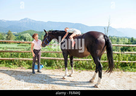 Bambina che giace a cavallo Foto Stock